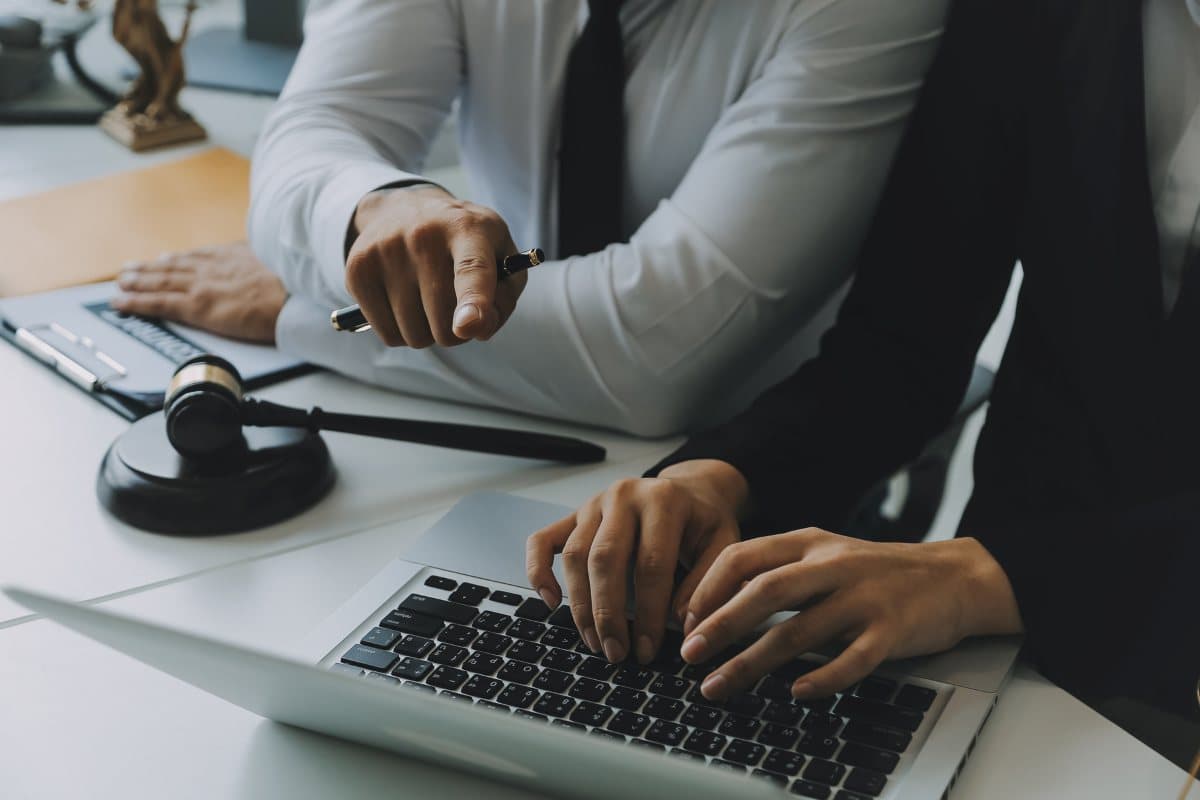 lawyers having team meeting with 1 lawyer using a laptop
